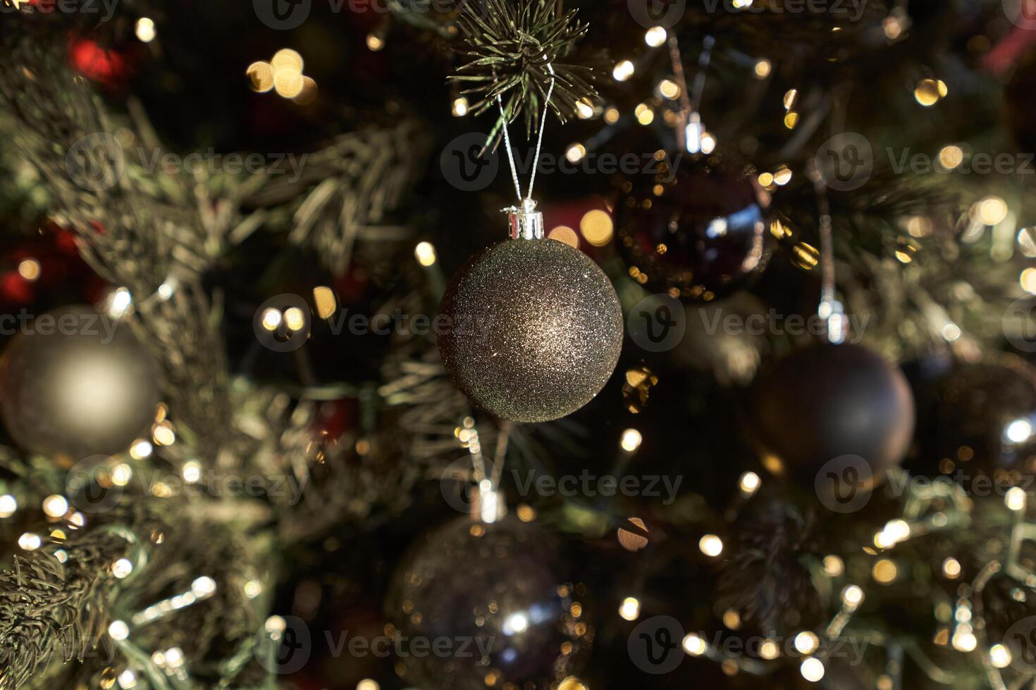 Shiny black balls on a decorated Christmas tree. Close-up with space to copy photo