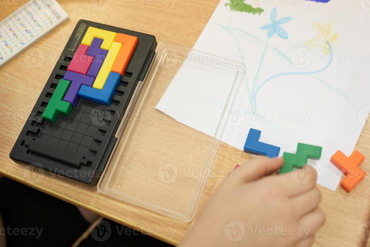 An unrecognizable child is playing a plastic-based puzzle game. Leisure time for children on vacation. With space to copy photo