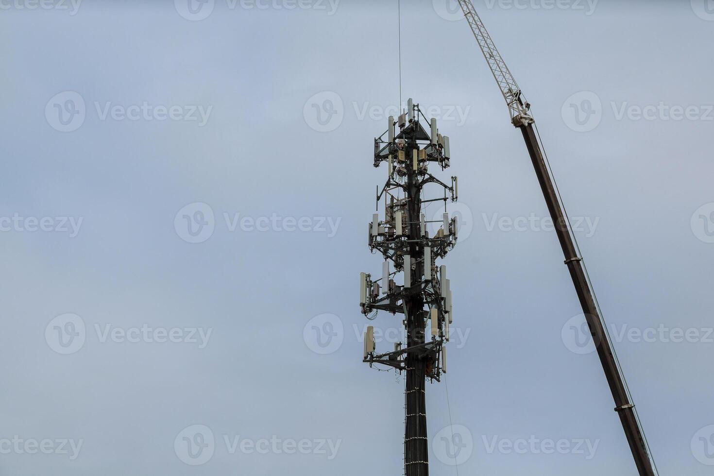Worker Cliping Carabiner Harness for Safety on Antenna Tower installation of telecommunication tower photo