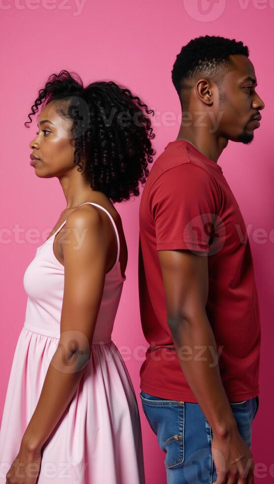 Portrait of a silent somber African American couple standing backtoback following a family argument on a pink studio background photo