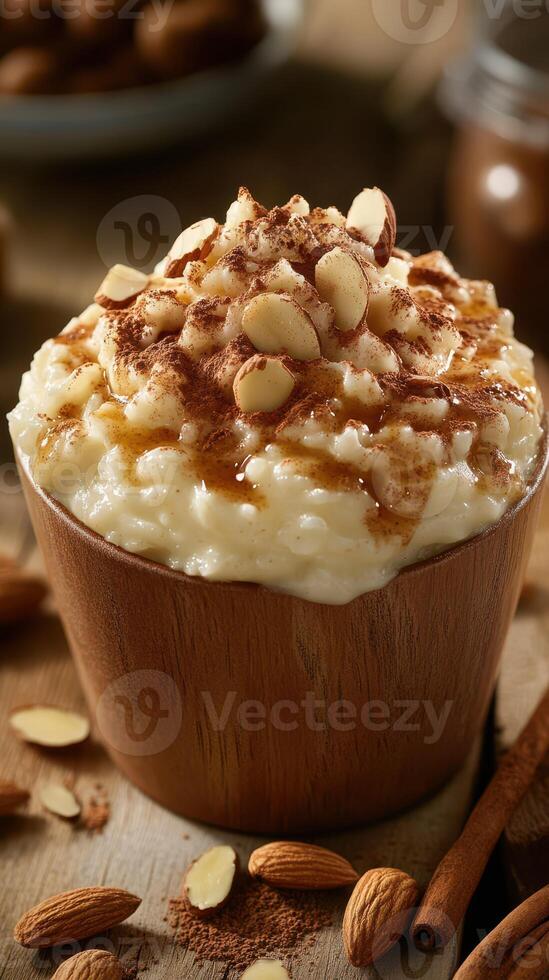 Creamy rice pudding topped with almonds and cinnamon served in a wooden bowl on rustic table photo