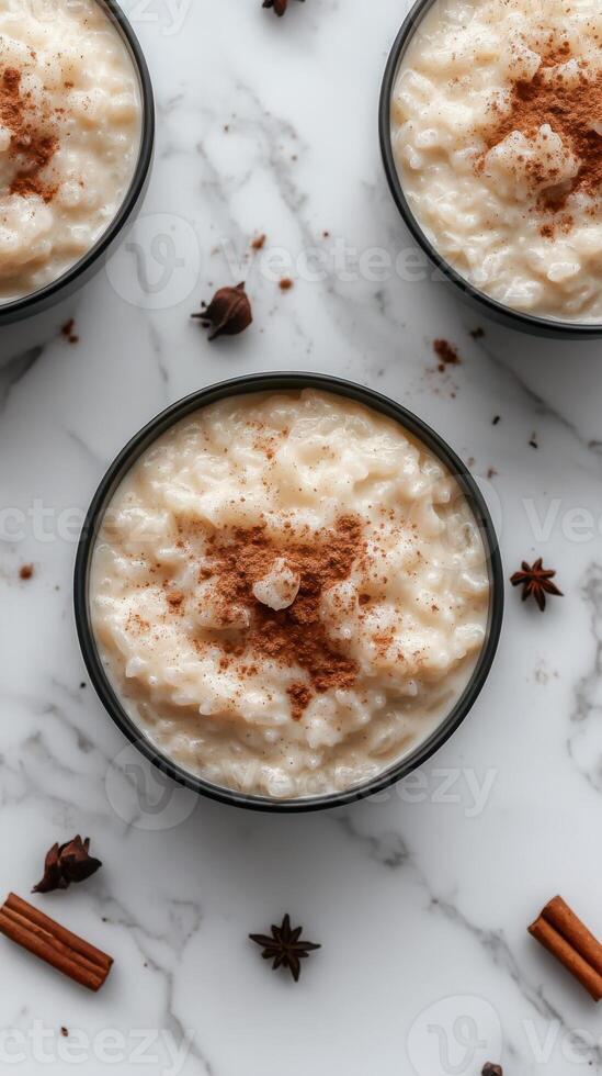 Creamy rice pudding topped with cinnamon and spices on a marble countertop photo