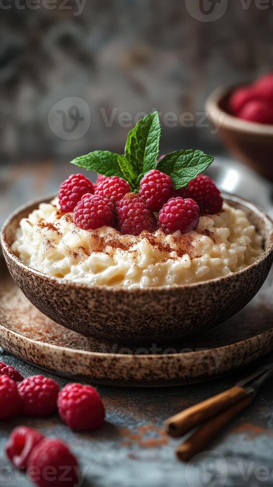 Creamy rice pudding topped with fresh raspberries and mint leaves in a rustic setting photo