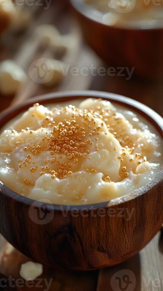 Creamy dessert served in wooden bowl with golden sprinkles and rich texture on rustic wooden table photo
