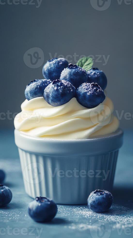 Delicious blueberry dessert topped with fresh berries and cream on a blue background in a cozy setting photo
