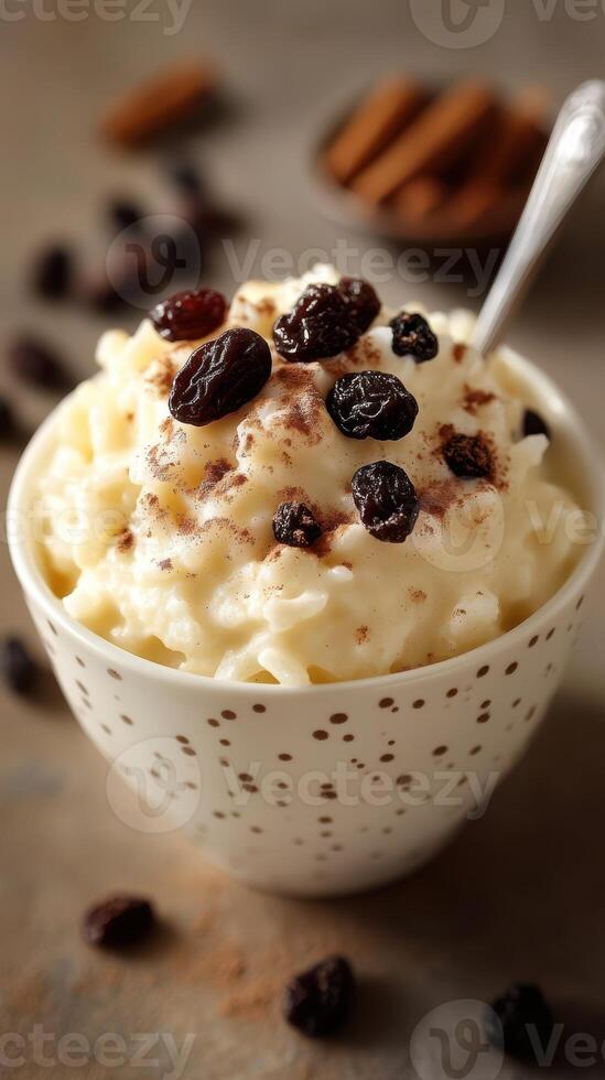 Creamy rice pudding topped with raisins and cinnamon in a decorative bowl photo