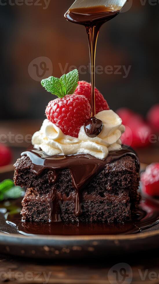 Chocolate dessert topped with cream and fresh raspberries on a wooden table photo