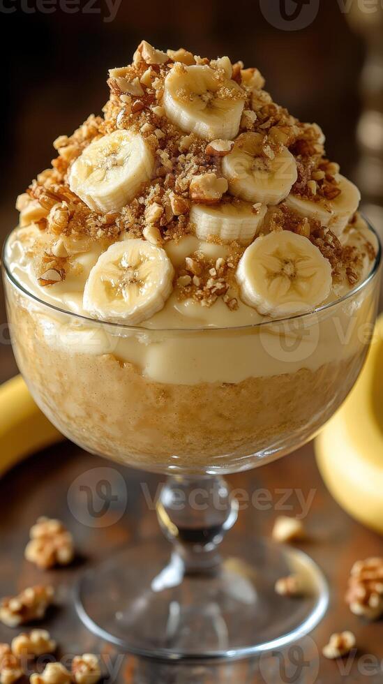 Delicious banana pudding dessert served in a glass bowl with crushed nuts and fresh banana slices on top photo