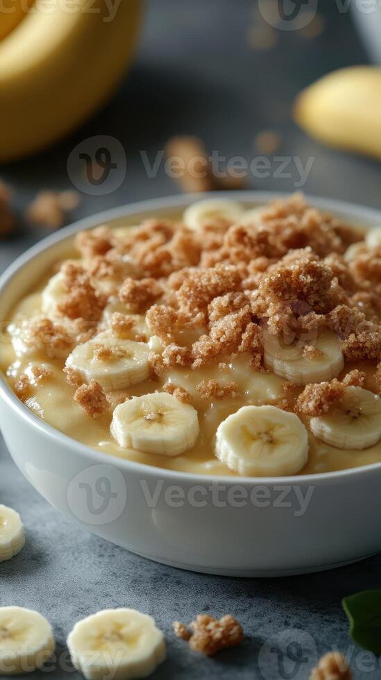 Creamy banana pudding topped with crunchy crumble served in a bowl with fresh bananas photo