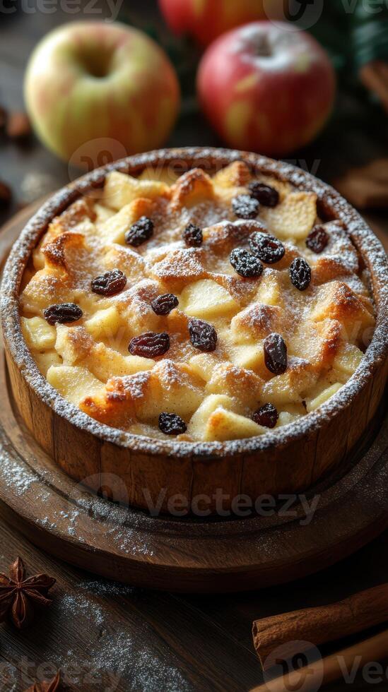 Delicious homemade apple bread pudding topped with raisins and powdered sugar in a rustic wooden bowl photo