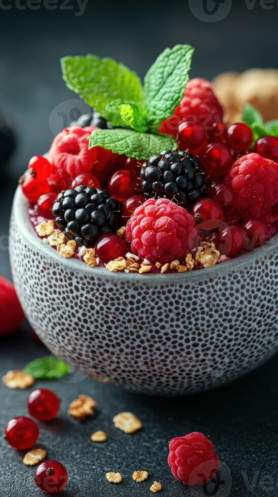 Fresh mixed berries with granola and mint served in a textured bowl for a healthy snack photo