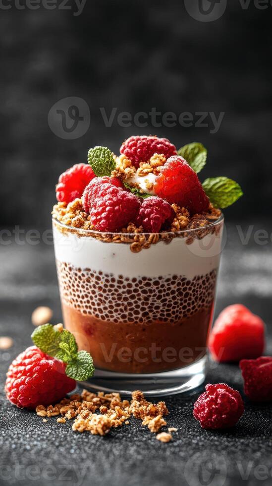 Dessert featuring layers of chocolate mousse, cream, and fresh raspberries served in a glass photo