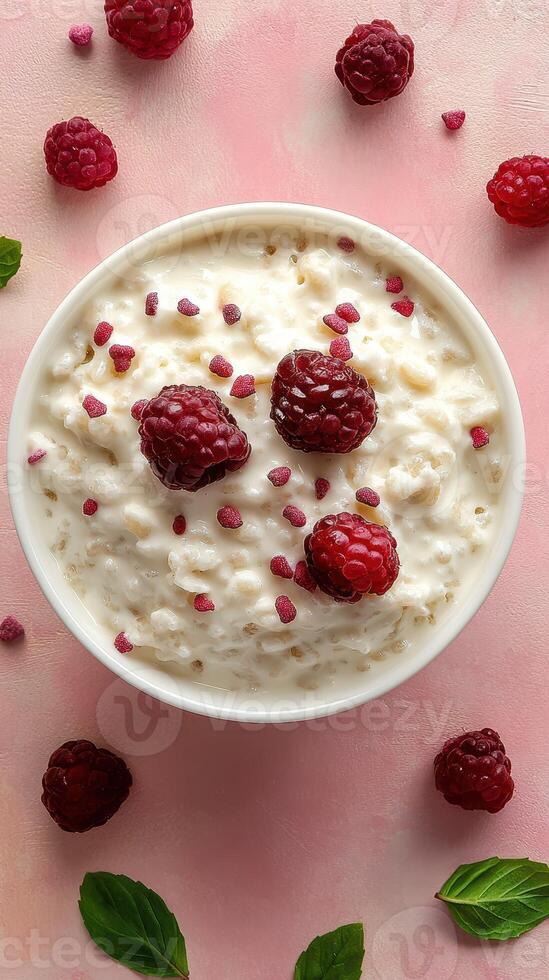 Delicious bowl of creamy cottage cheese topped with fresh raspberries and mint on a pastel pink background photo