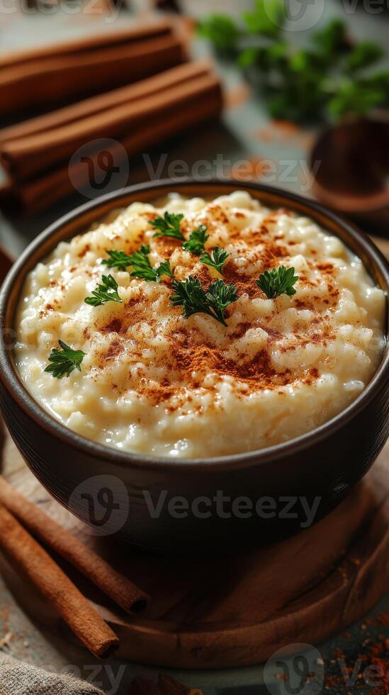 Delicious bowl of creamy rice pudding topped with cinnamon and herbs on a rustic table photo