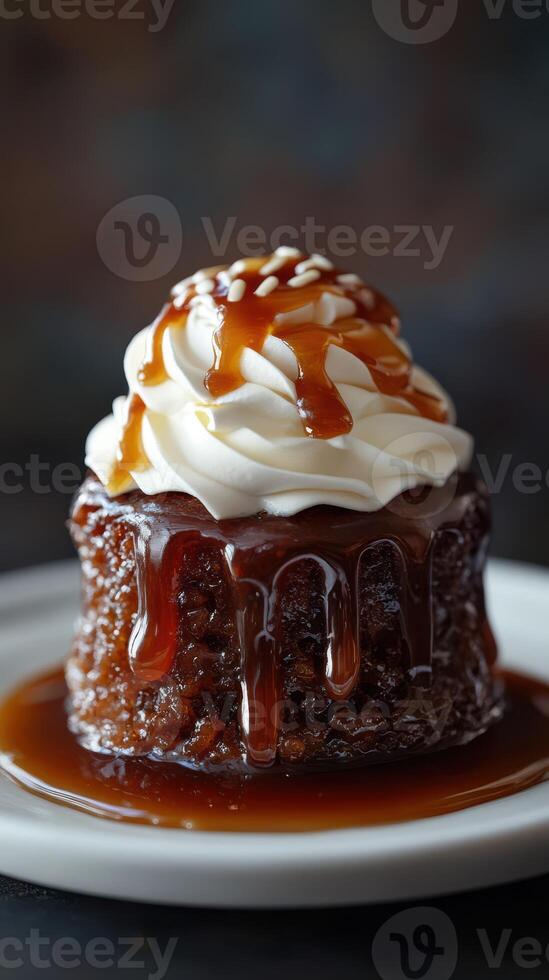 Moist caramel pudding with whipped cream topping served on a white plate photo