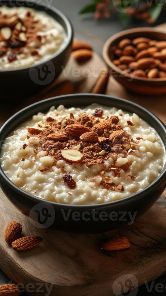 Delicious rice pudding with almonds served in black bowls on a wooden table photo