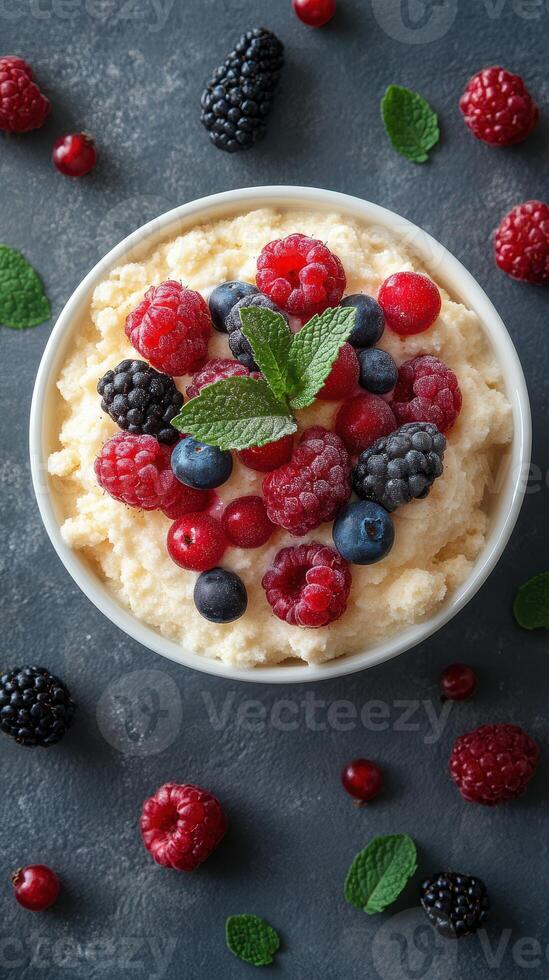 Delicious berry dessert topped with fresh fruits and mint leaves on a dark background photo