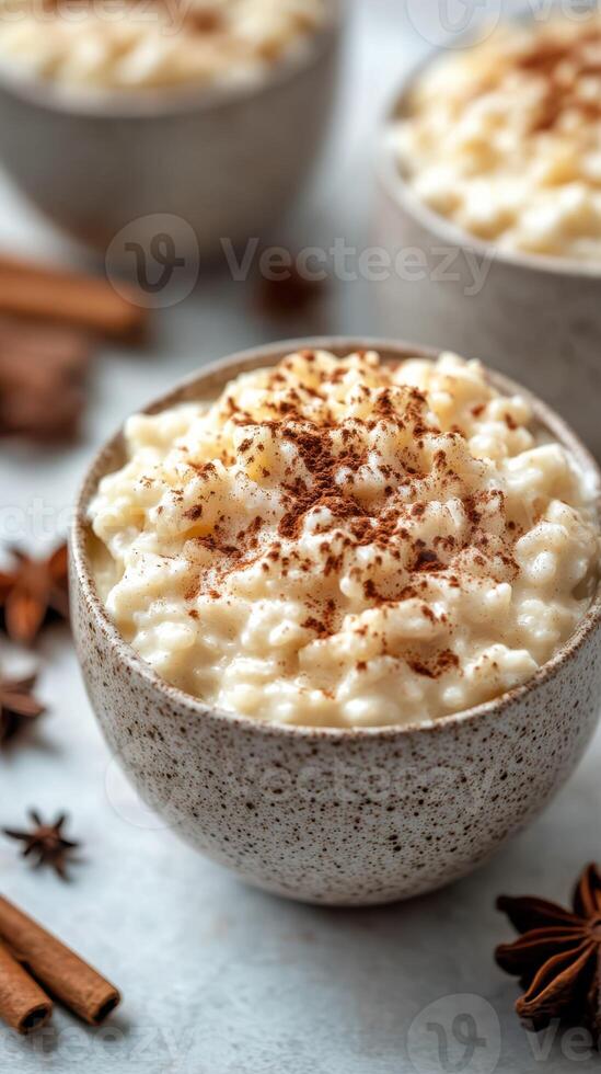 Creamy rice pudding topped with cinnamon sits in rustic bowls surrounded by fragrant spices photo