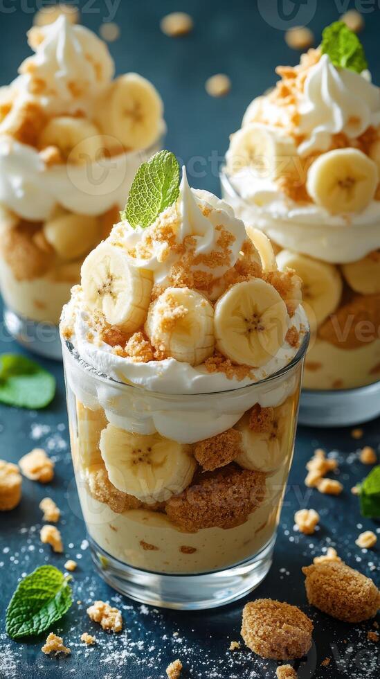Delightful banana puddings topped with whipped cream and mint leaves served in glass cups at a dessert table photo