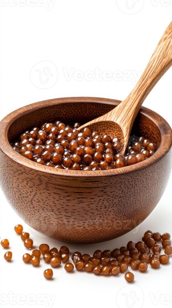 Brown pearls of tapioca served in a wooden bowl with a spoon for dessert preparation and cooking at home photo