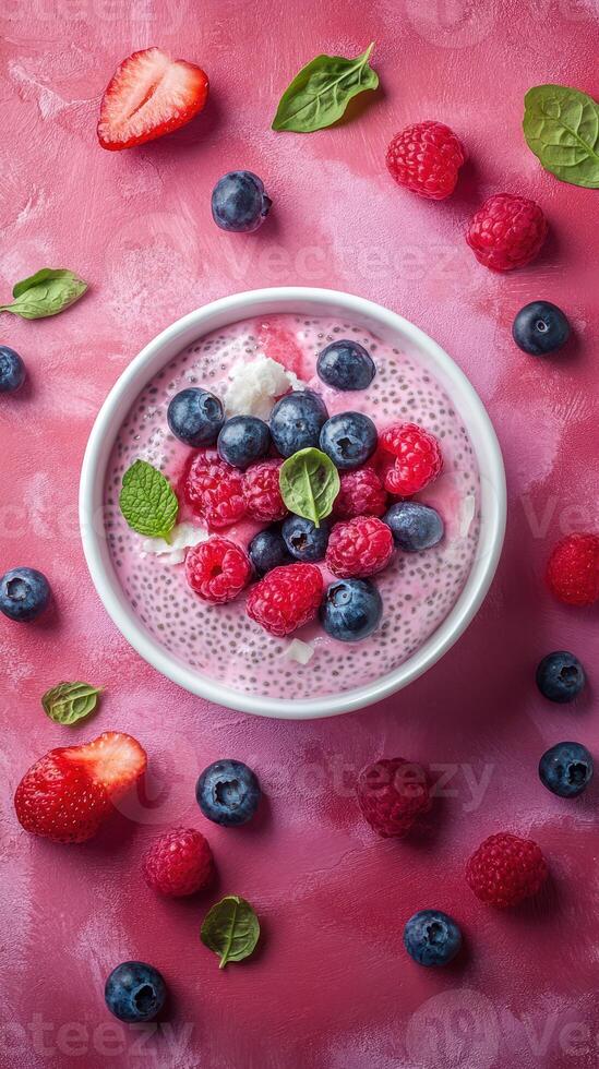 Colorful berry yogurt bowl with fresh fruit and mint on a pink background, showcasing healthy toppings for a vibrant breakfast photo