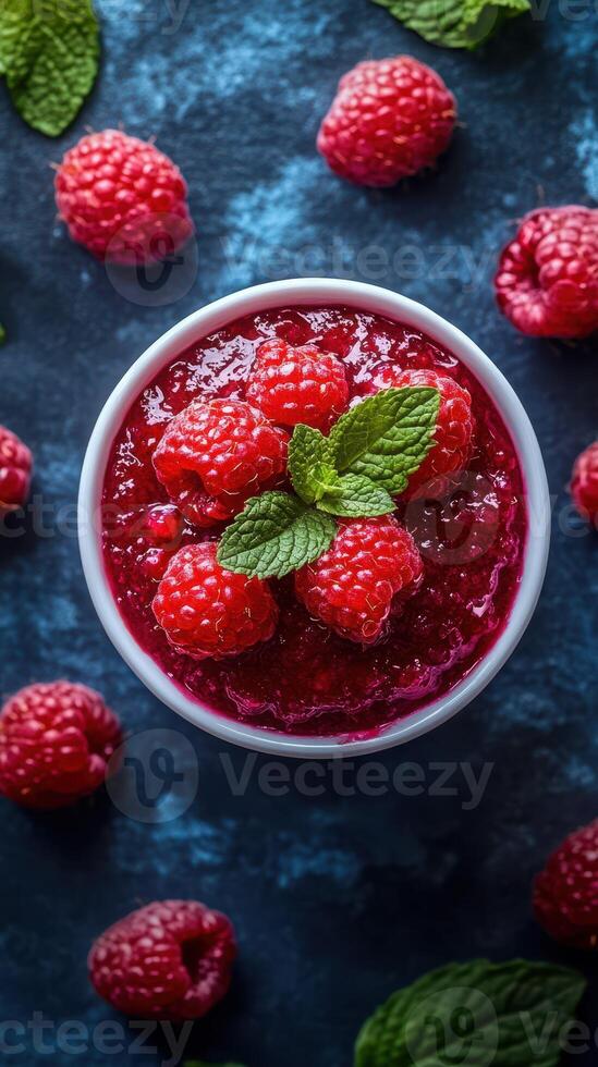 Fresh raspberry dessert topped with mint leaves on a dark textured background photo