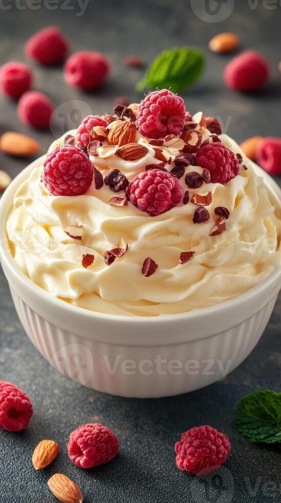 Creamy dessert topped with fresh raspberries and almonds in a white bowl on a textured surface photo