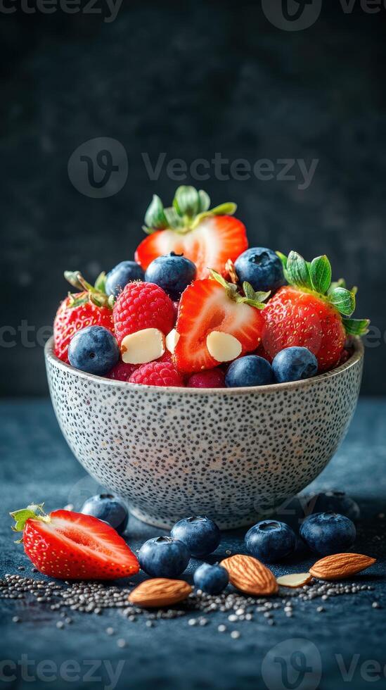 Colorful bowl filled with fresh berries and almonds on a textured blue background in a bright kitchen setting photo