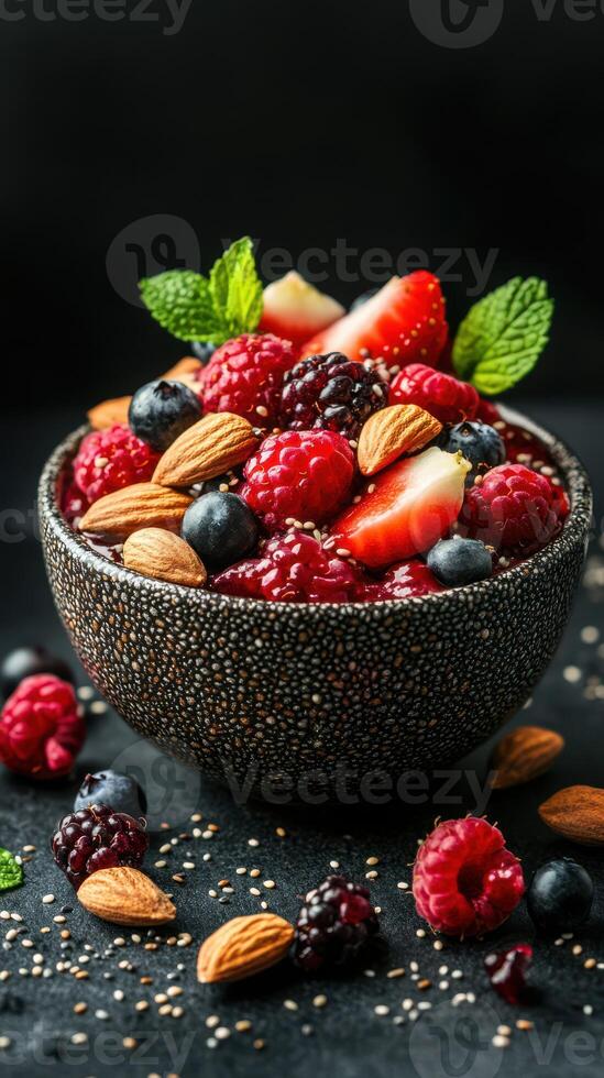 Fresh berries and almonds in a decorative bowl on a dark background photo