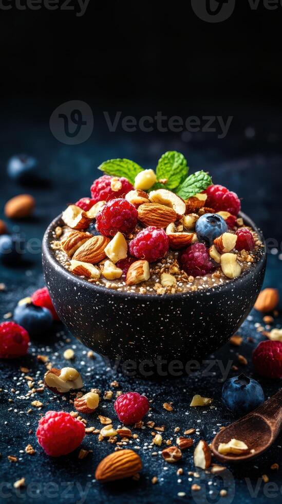 Delicious bowl of mixed berries, nuts, and granola served on a dark surface with scattered ingredients photo