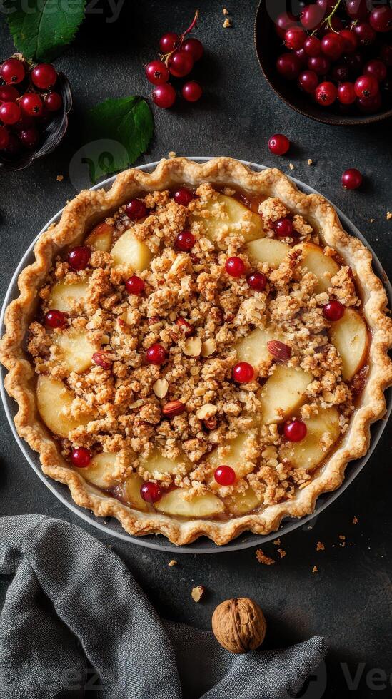 Delicious fruit pie with crumb topping featuring apples and red currants on a dark background photo