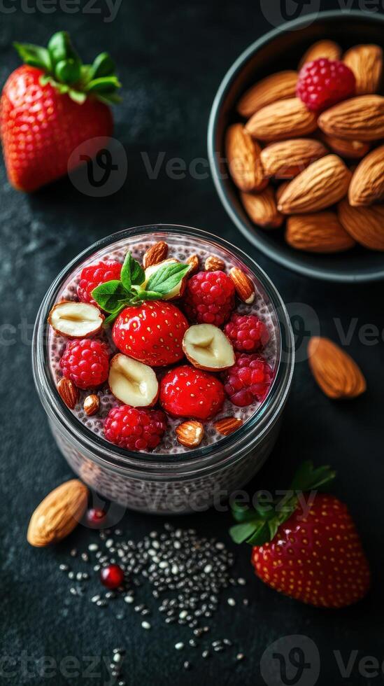 Healthy chia seed pudding topped with fresh strawberries and almonds in a bowl on a dark surface photo