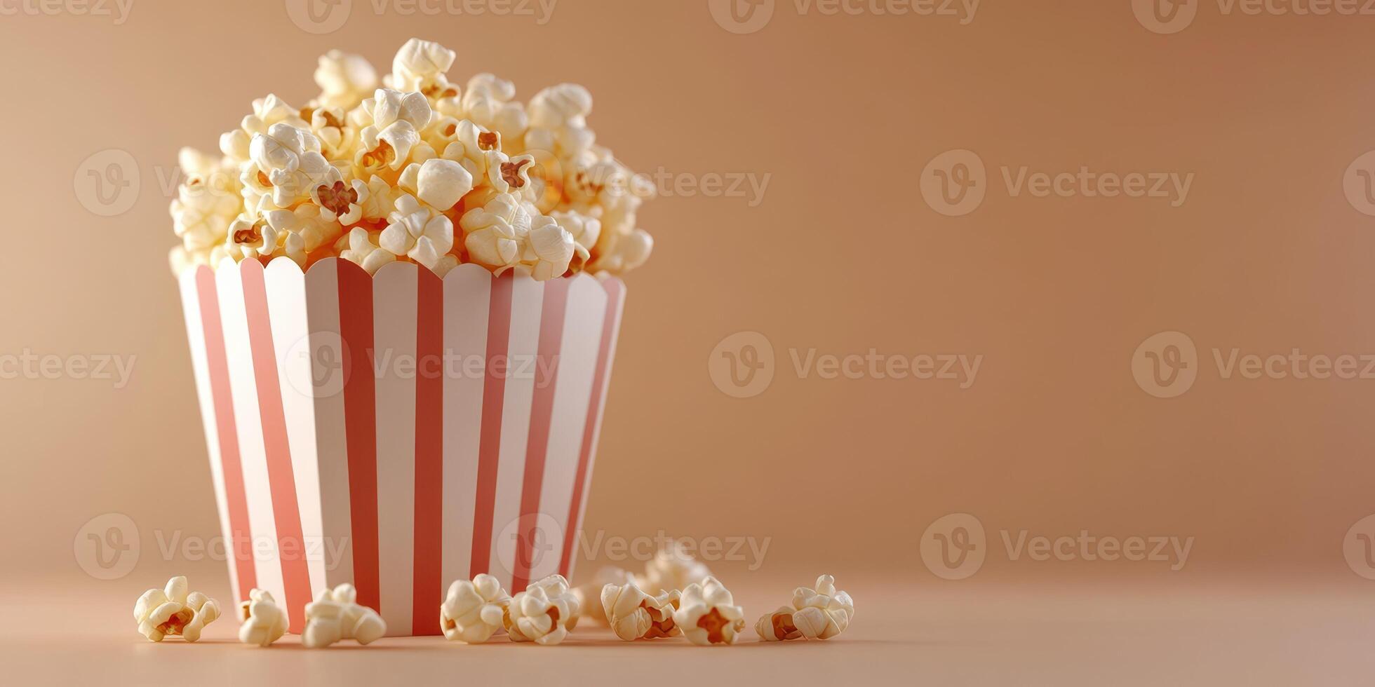 Freshly popped popcorn in a striped container on a plain background ready for movie night photo
