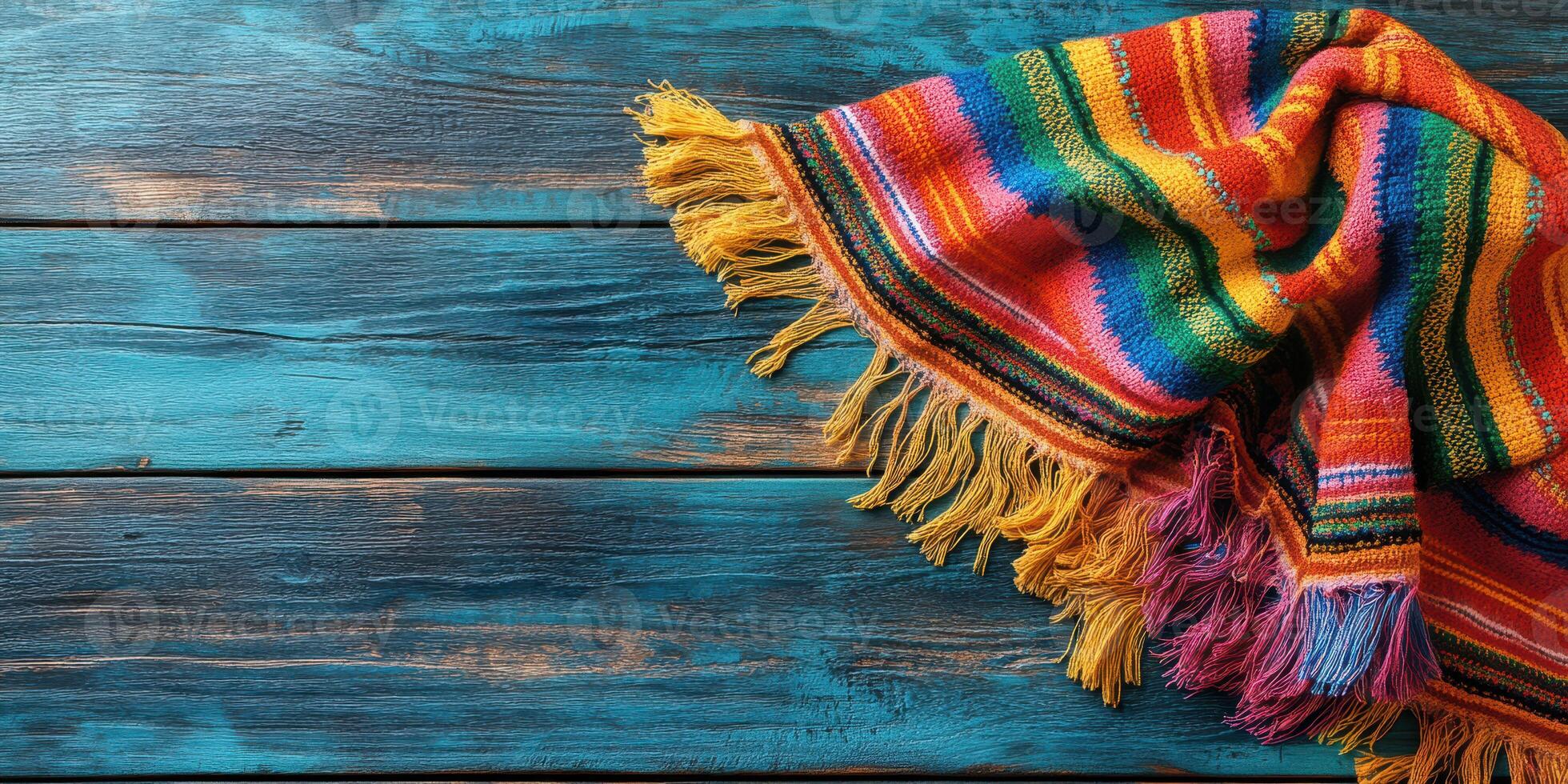 Colorful woven blanket draped on rustic wooden table showcasing vibrant texture and design photo