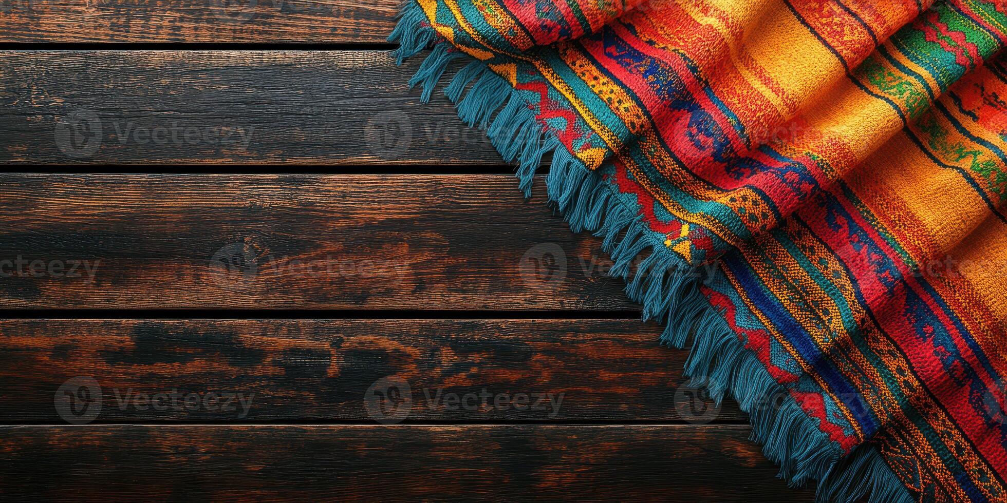 Colorful woven blanket draped on a rustic wooden surface showcasing intricate patterns and vibrant hues photo