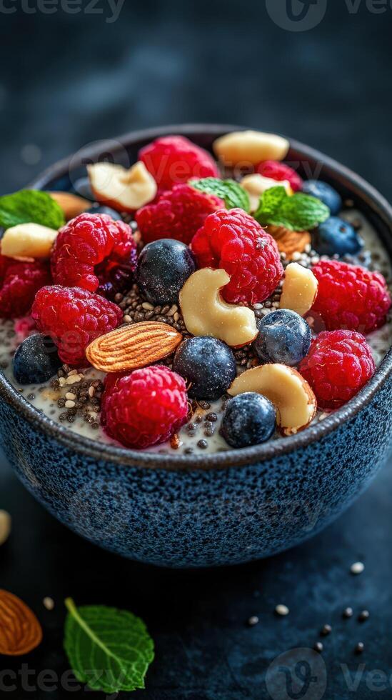 Colorful berry bowl topped with nuts and seeds served in a textured blue bowl for a healthy breakfast option photo