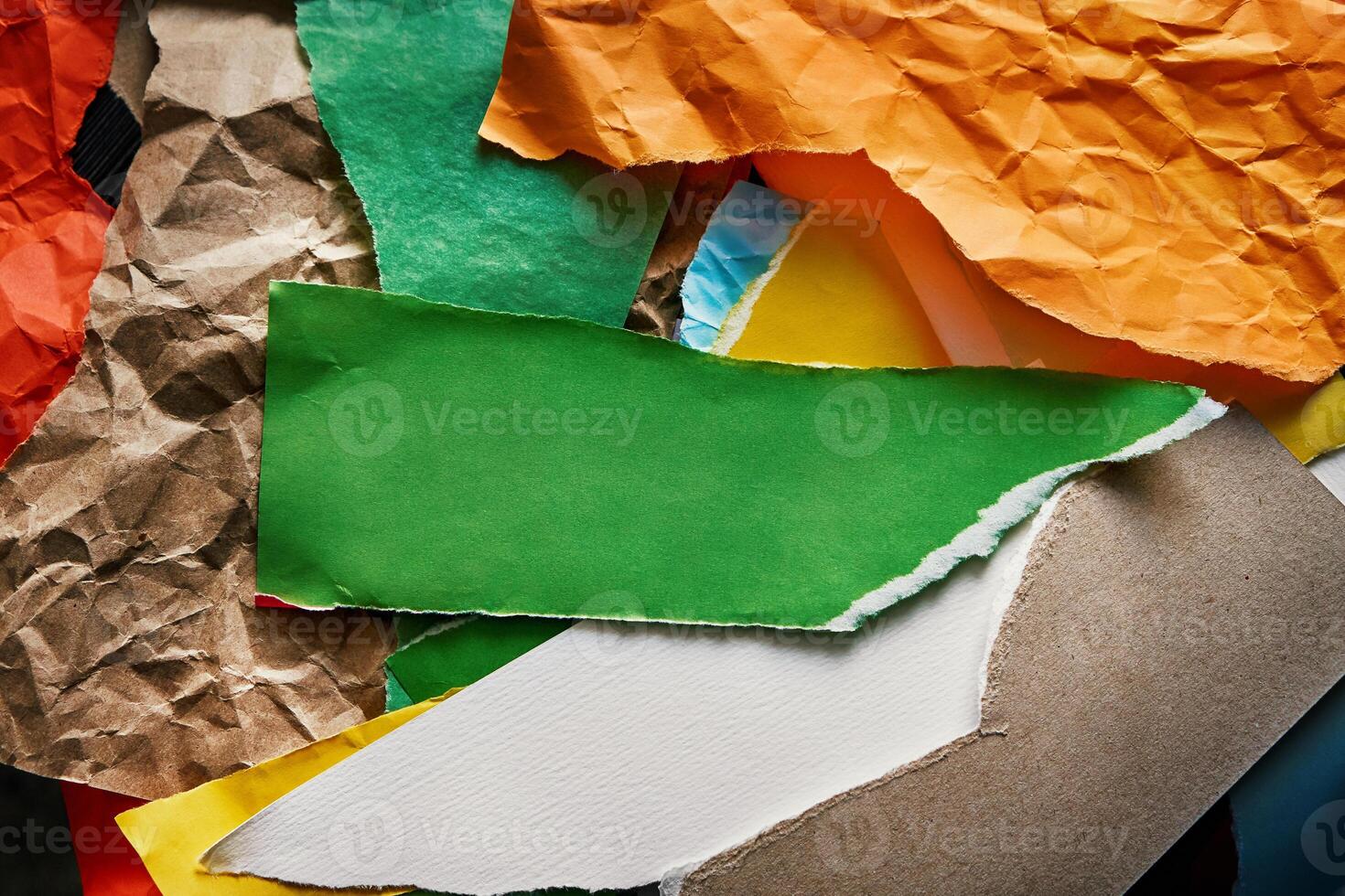 Torn and crumpled color papers surface with place for terxt photo