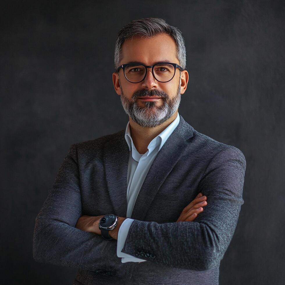 Portrait of a successful businessman with beard and glasses standing in front of black background photo
