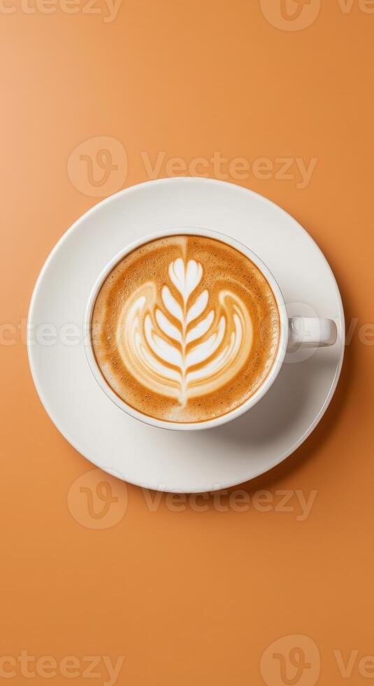 A latte with a heart in the foam on an orange background photo