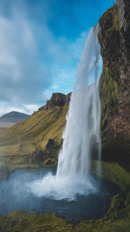Closeup of seljalandsfoss flowing from mountn agnst cloudy blue sky. High Resolution photo