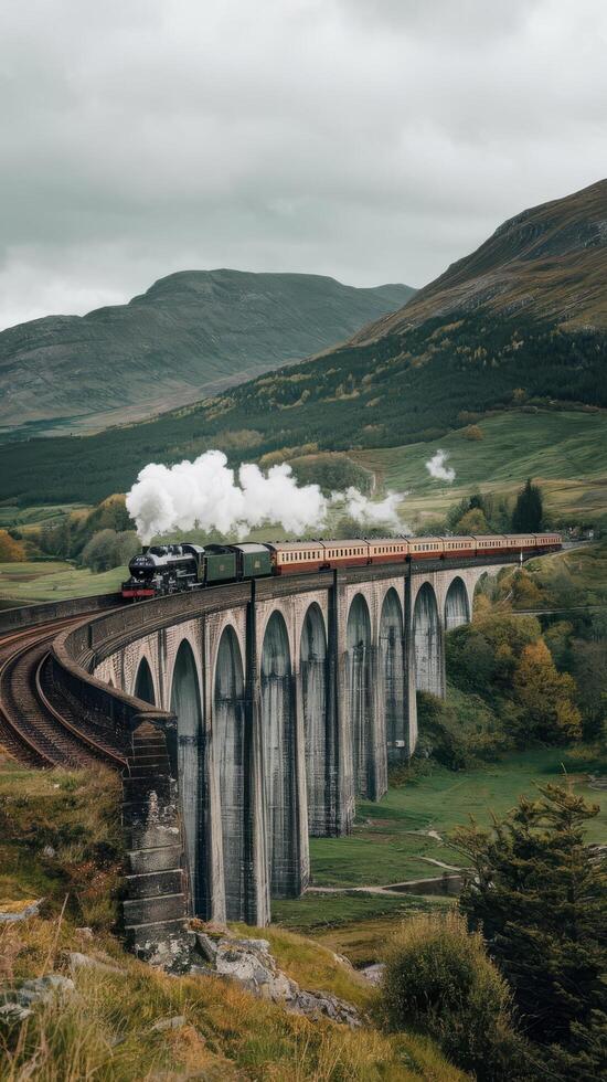 A steam train traveling over a bridge in the countryside photo