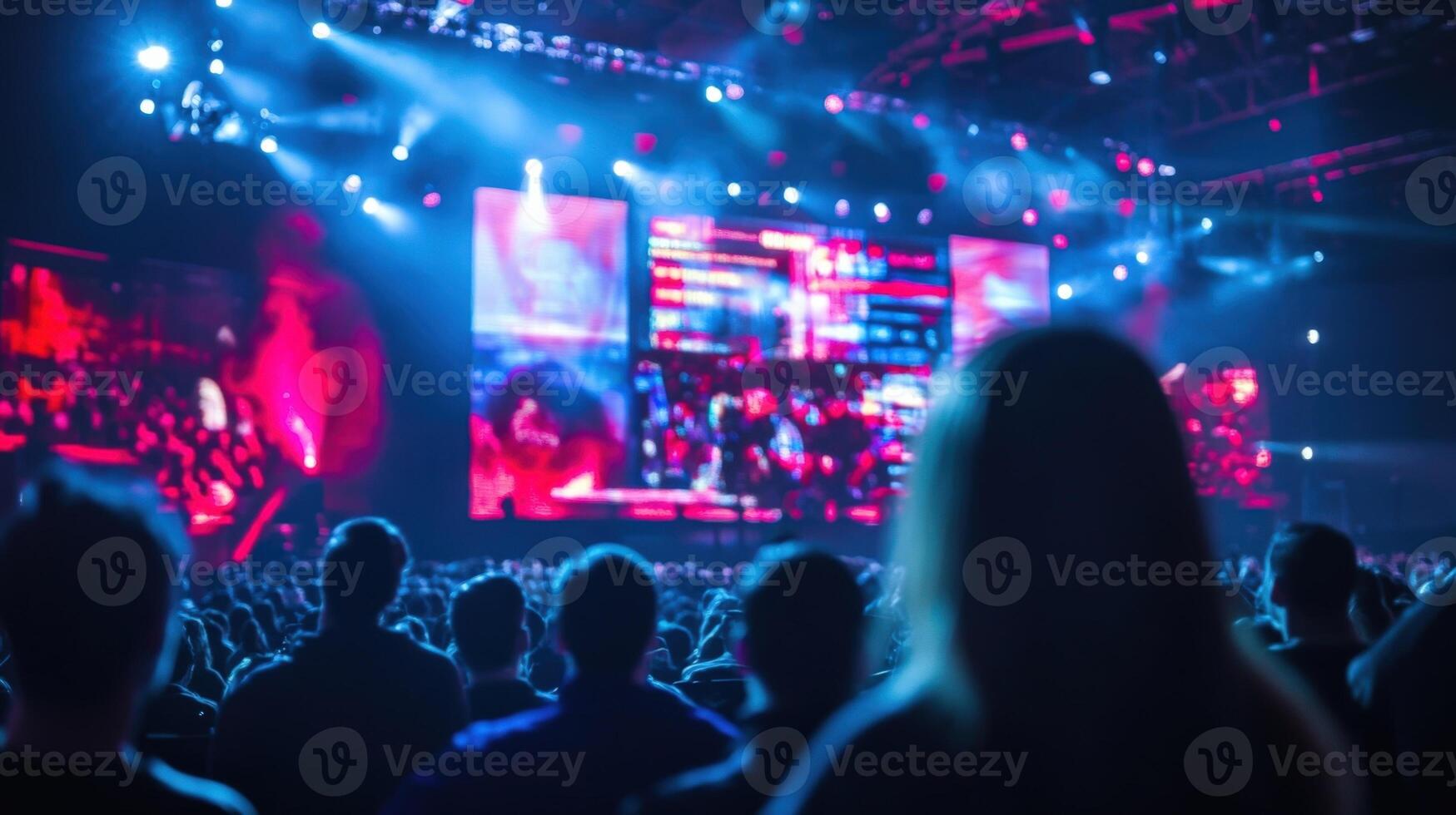 Wide shot of the game shows host energetically engaging with the audience gesturing towards a large creatively designed digital scoreboard that features blurring effects adding a sens photo