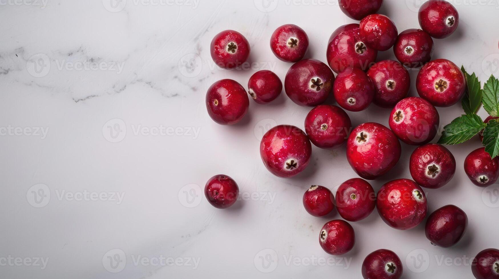 Fresh cranberries scattered on a marble surface, with a mint leaf accent. photo