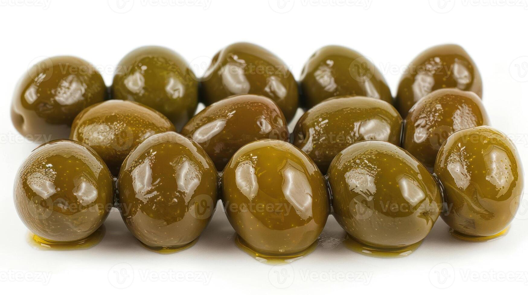 A cluster of shiny green olives arranged on a white surface. photo