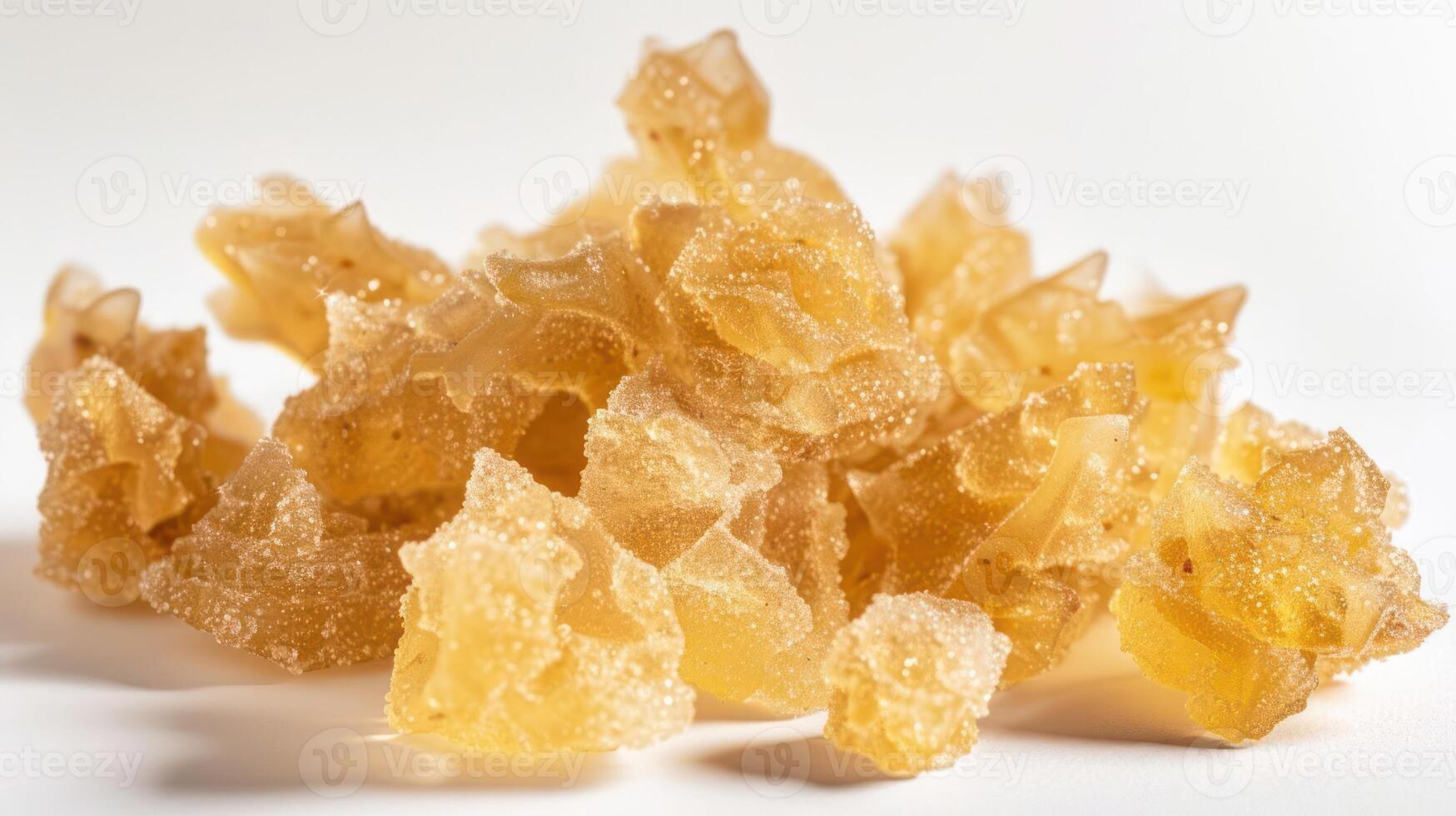 A pile of translucent, golden resin-like crystals on a white background. photo