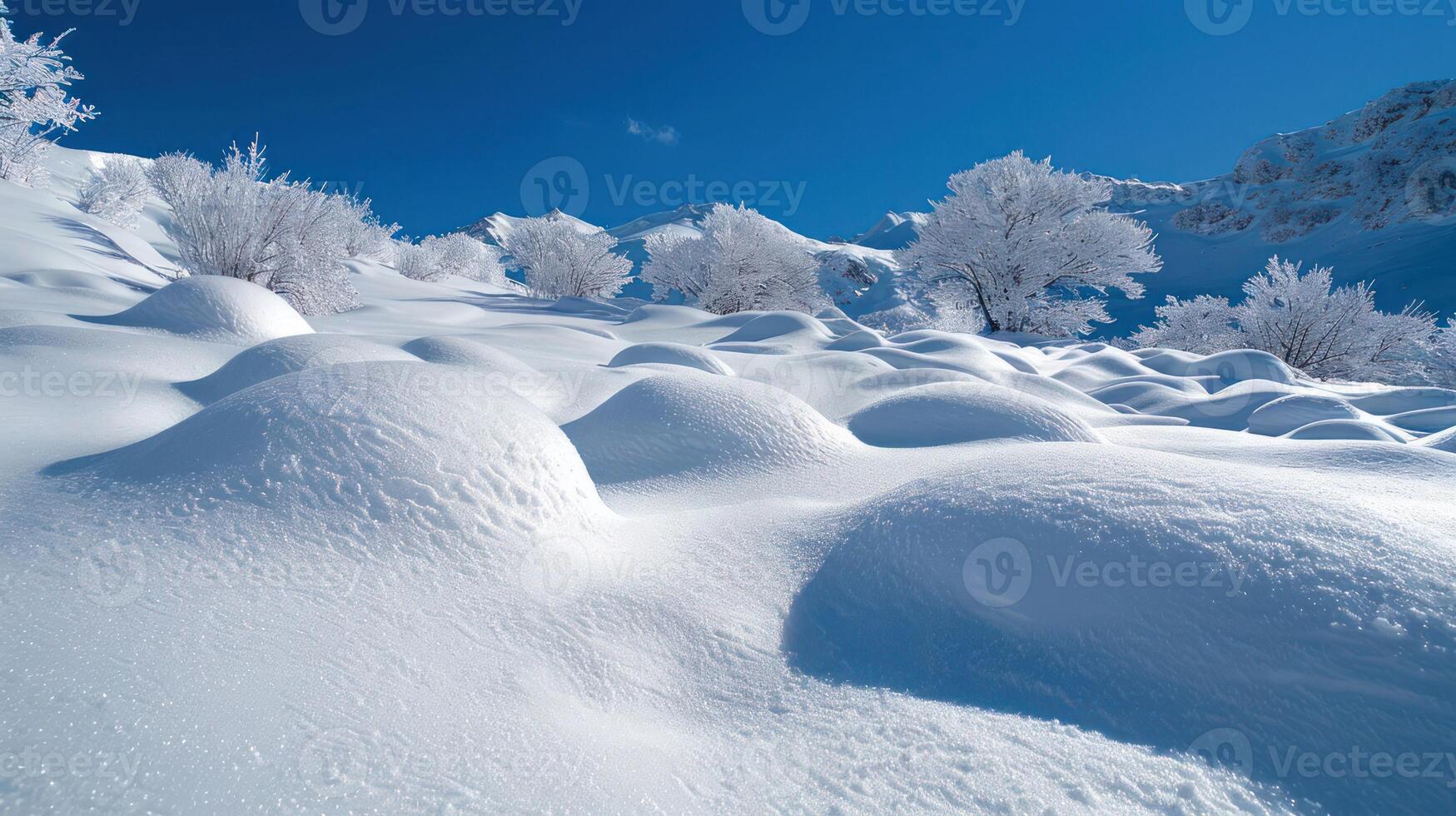 A serene winter landscape blanketed in smooth, untouched snow under a clear blue sky. photo
