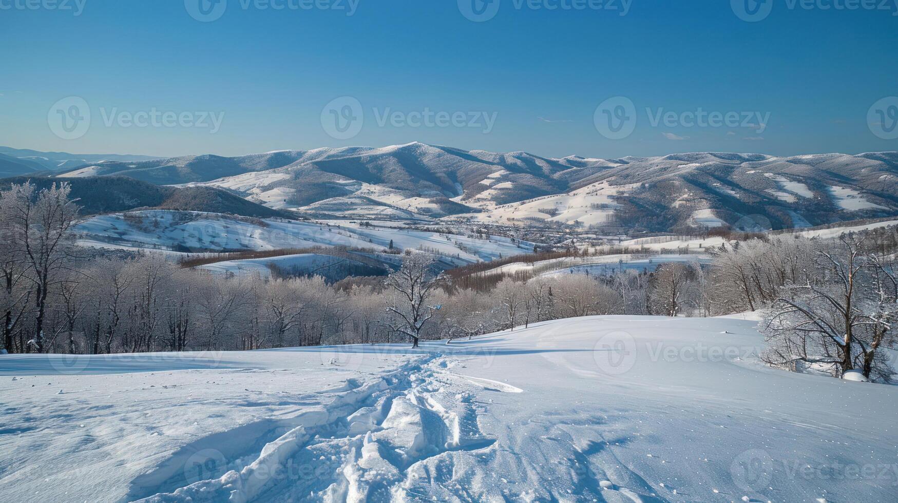 A serene winter landscape with snow-covered hills and clear blue sky. photo