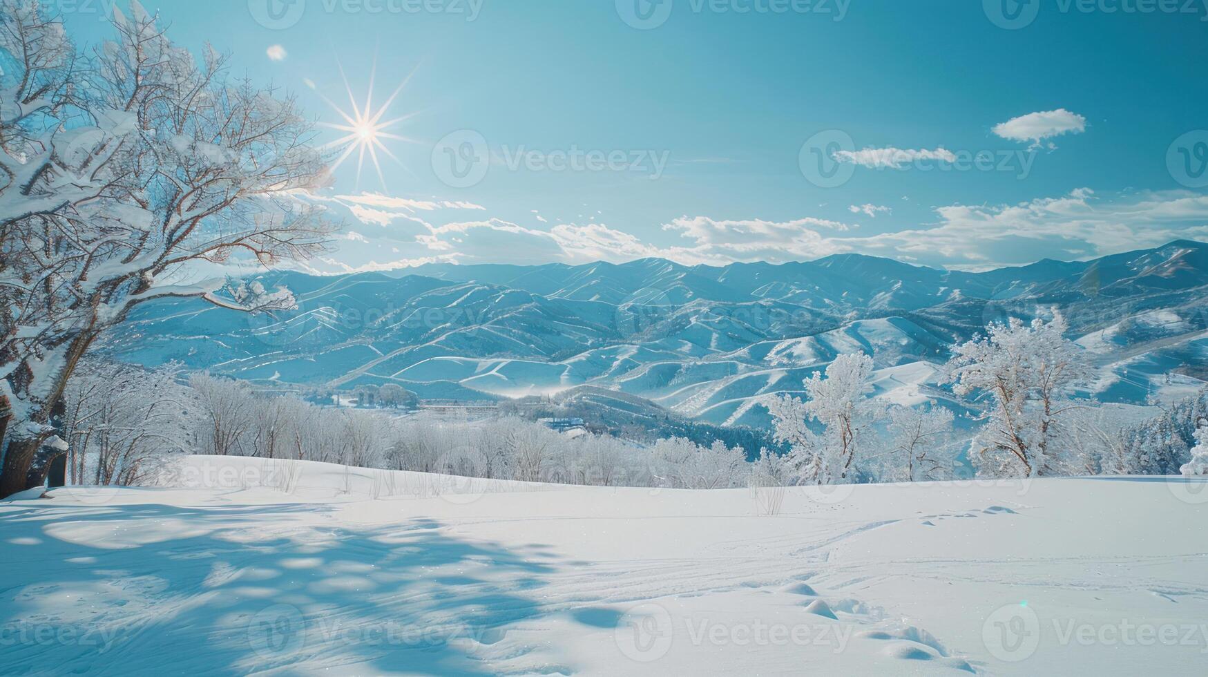 A serene winter landscape featuring snow-covered mountains under a bright blue sky. photo