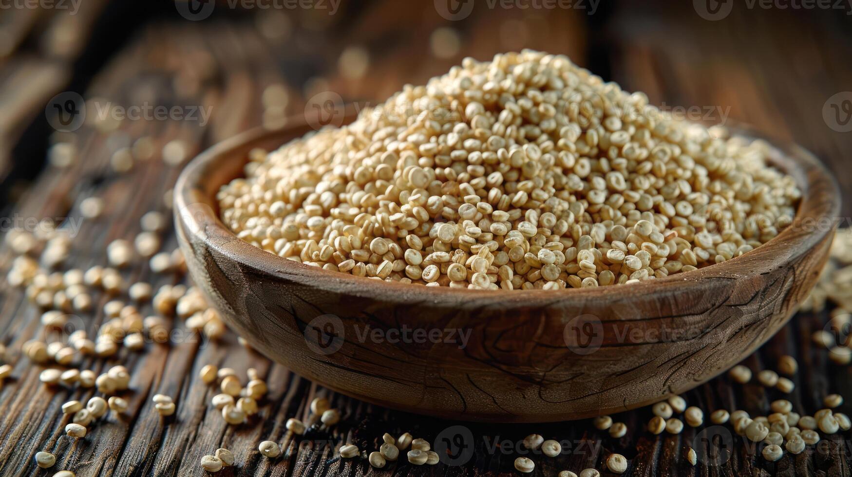 A wooden bowl filled with quinoa grains, surrounded by scattered grains on a rustic wooden surface. photo