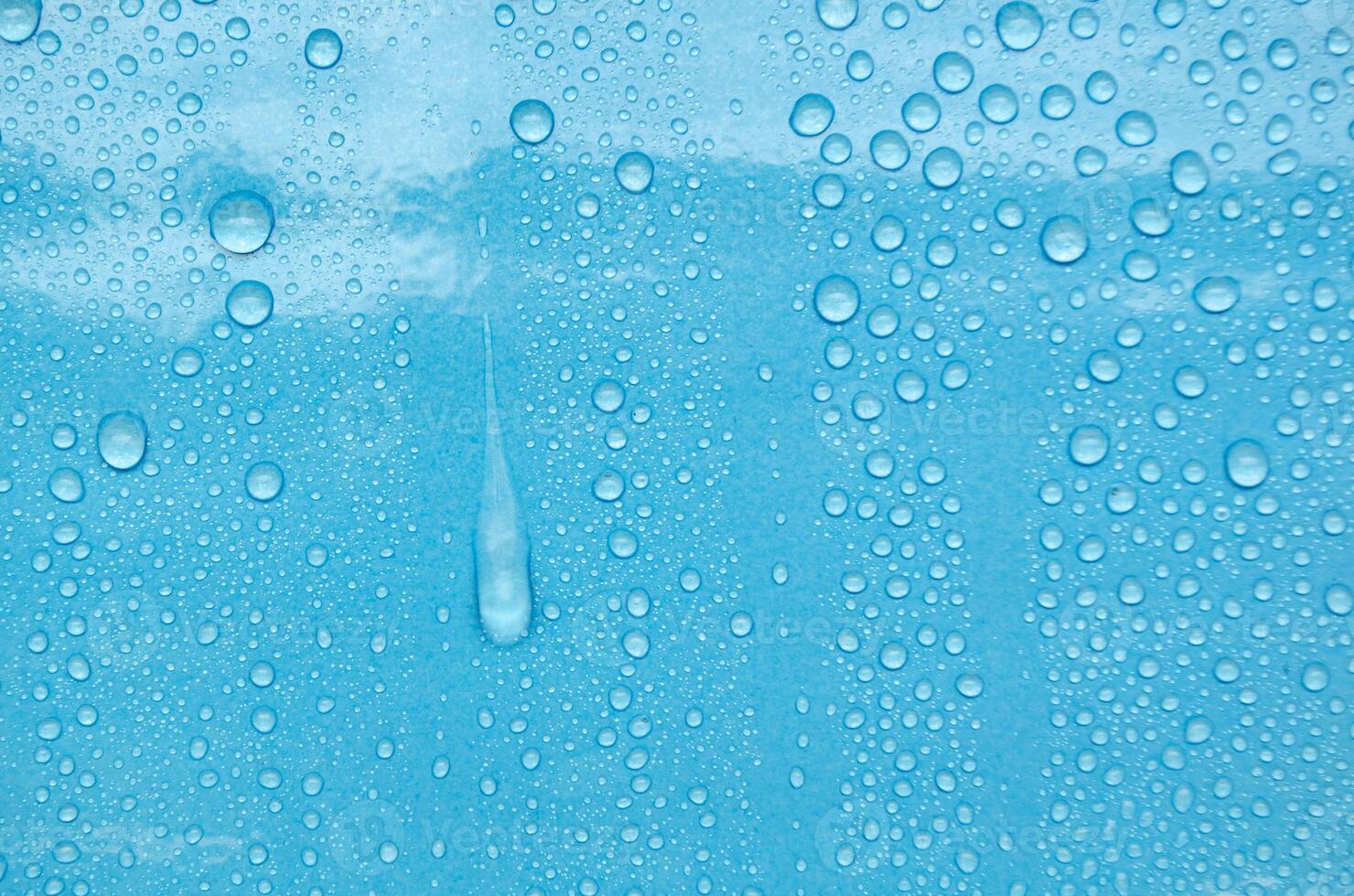 Rain water droplets with ocean blue color background suitable for wallpaper photo